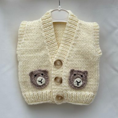 Handgestrickte Babyweste in Creme mit Bärchen-Details